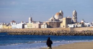 Descubre las costas andaluzas: destinos costeros para todos los gustos Una playa de Cádiz con la catedral al fondo costas andaluzas
