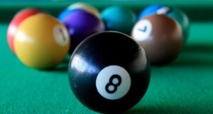 El billar y sus secretos desde las mesas hasta los tacos Una mesa de billar con tacos y bolas de diferentes tamaños, representando las variantes de carambola, pool y snooker, con un enfoque en la precisión y el mantenimiento de las mesas y el equipo.