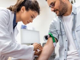 Enfermera atendiendo a un paciente en su casa en Sitges durante una consulta médica domiciliaria