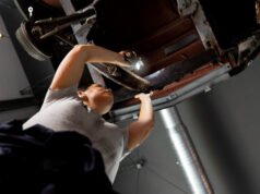 Servicio especializado en arreglos rápidos de escapes y catalizadores automotrices Mecánico revisando el sistema de escape de un coche en taller especializado