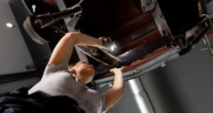 Servicio especializado en arreglos rápidos de escapes y catalizadores automotrices Mecánico revisando el sistema de escape de un coche en taller especializado