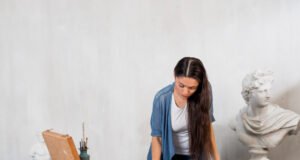 Criterios fundamentales al solicitar la valoración de obras de arte antiguas Especialista examinando un cuadro antiguo con lupa en un entorno de museo o galería.