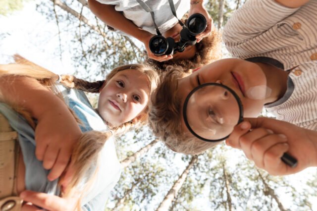 D2Naturaleza Grupo de estudiantes realizando una excursión escolar en la naturaleza, observando plantas y animales con sus docentes