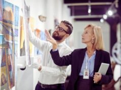 Profesionales clave para asegurar y valorar colecciones de arte con precisión Especialista analizando una obra de arte para su peritaje y valoración profesional.