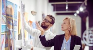 Profesionales clave para asegurar y valorar colecciones de arte con precisión Especialista analizando una obra de arte para su peritaje y valoración profesional.