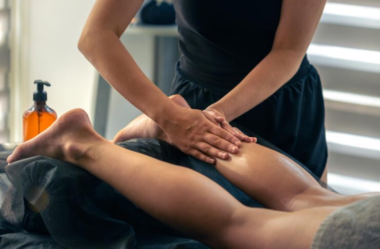 Masajista deportivo realizando tratamiento muscular a un atleta en Mallorca tras una sesión de entrenamiento.