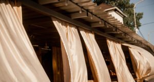 Las mejores tendencias textiles para el verano Sofá con tapicería de lino y decoración en tonos naturales en un salón luminoso de estilo veraniego.