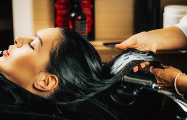 Profesional realizando tratamiento capilar en una peluquería unisex de Sant Gervasi.