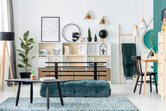 Salón moderno con muebles auxiliares de madera natural, estanterías decorativas y mesas auxiliares de diseño contemporáneo.